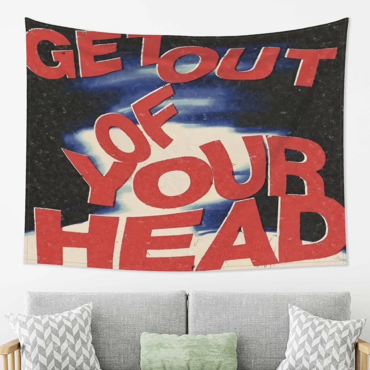 A dark tapestry wall hanging with red text that reads Get Out of Your Head