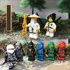 A collection of golden ninja building block figures in various poses and colors set against a natural, mossy background.