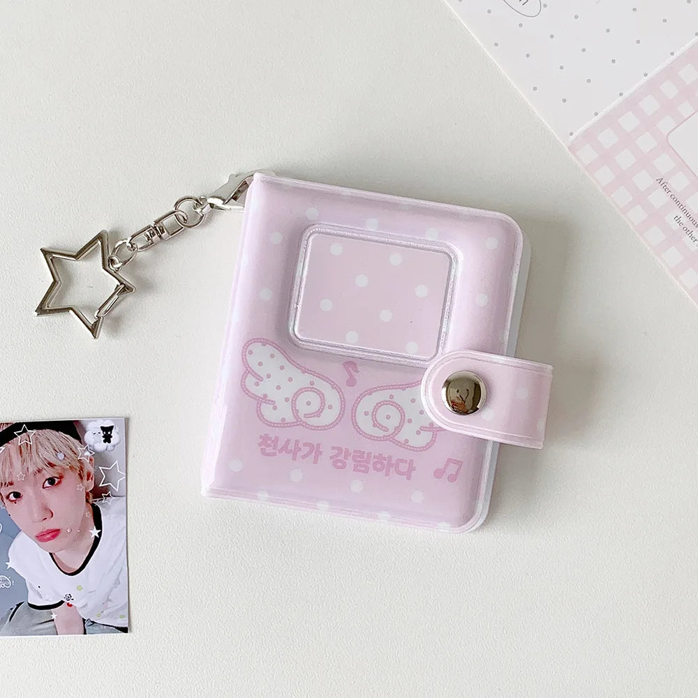 A pink mini snap button photo album with a clear window and a decorative design, attached to a silver chain.