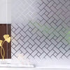 Frosted electrostatic window film applied to a white tile wall with a black geometric pattern.