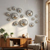 A modern living room wall decorated with a cluster of reflective silver disco balls.