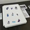 A white notebook features various cartoon graffiti stickers related to a story or series.