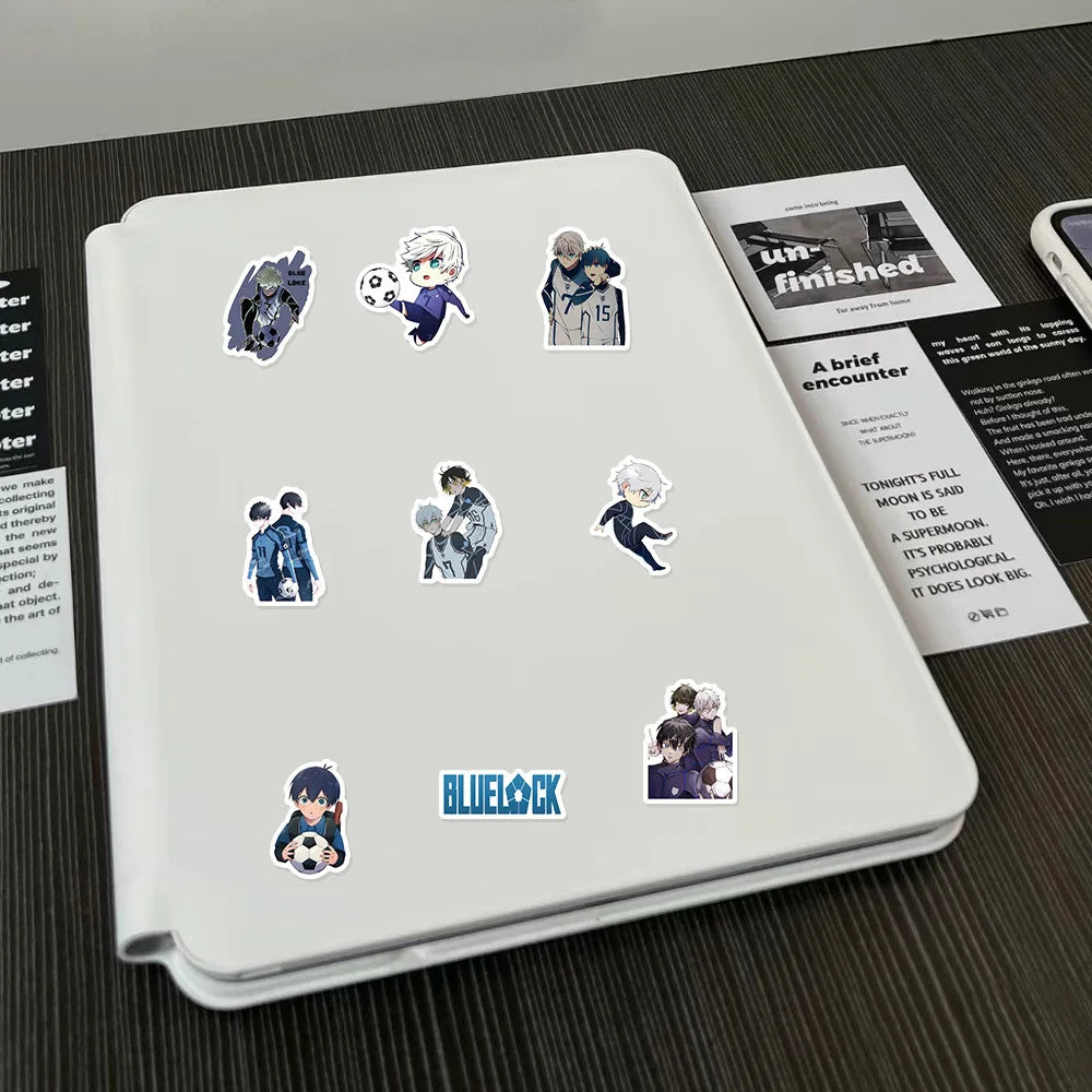 A white notebook features various cartoon graffiti stickers related to a story or series.