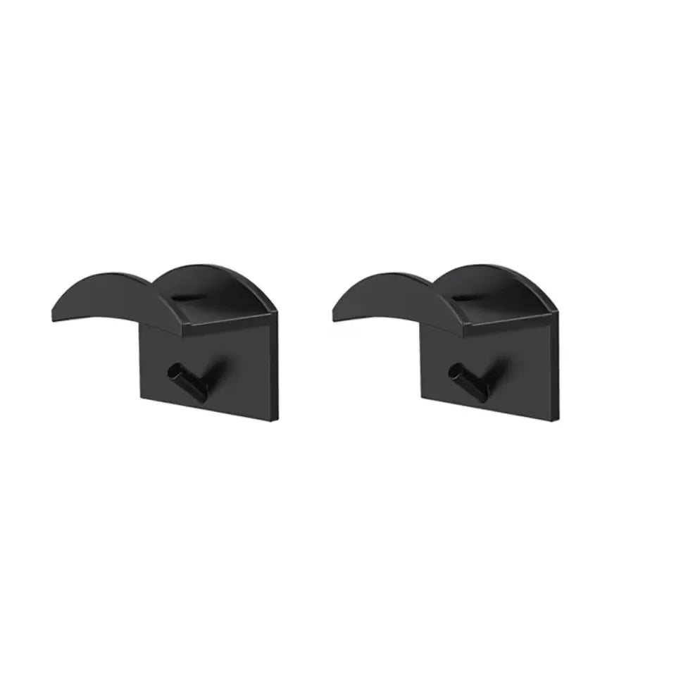 A pair of black no-drill adhesive hat hooks for wall storage.