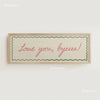 A framed canvas print with a light background and pink text that reads Love you, byeee!
