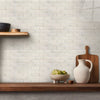 A white subway tile wall is displayed with wooden cutting boards and a white ceramic pitcher and bowl.