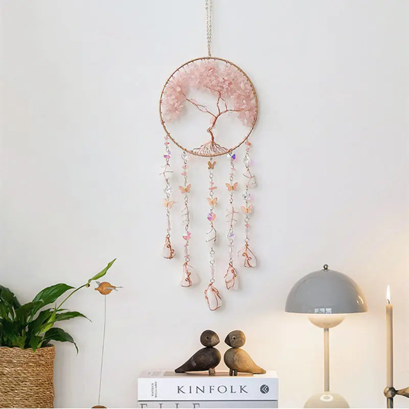 A delicate pink crystal tree of life sun catcher wall decor with hanging crystal elements.