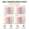A set of four pink wall-mounted display shelves with wooden supports and various sizes for storage.