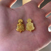 Two golden tortoise figurines for wealth luck home decor resting on a person's hand.