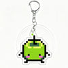 A clear acrylic keychain charm featuring a pixel art green monster face.