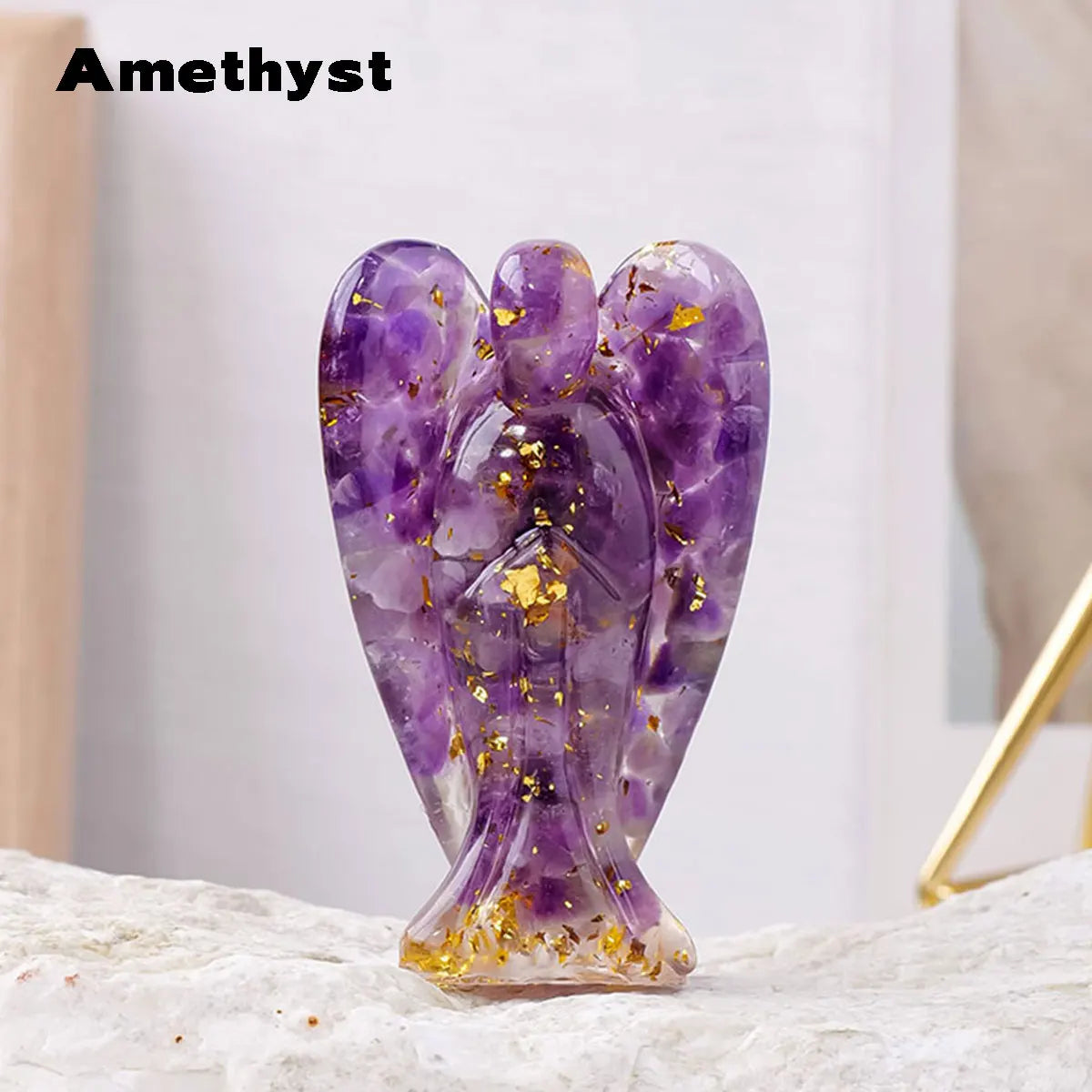 A natural amethyst crystal figurine shaped like a guardian angel with gold accents.
