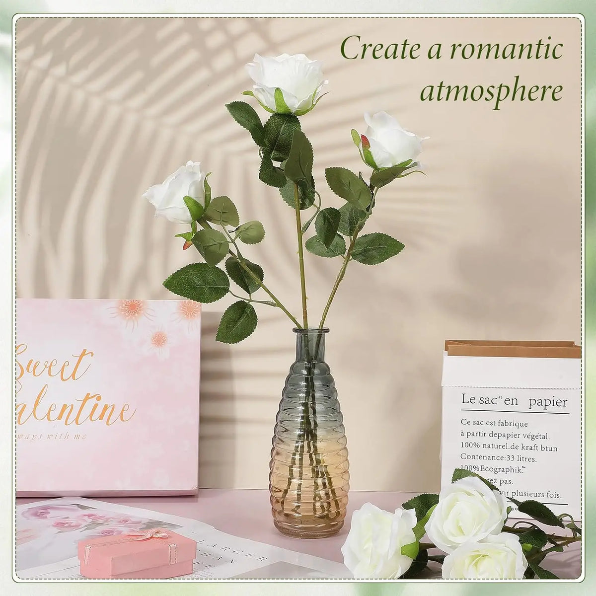 A bouquet of white artificial silk roses in a glass vase on a pink surface with natural light.