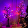 Dekorativer Baum-Schatten, beleuchtet mit lila und rosa LED-Lichtern vor dunklem Hintergrund.