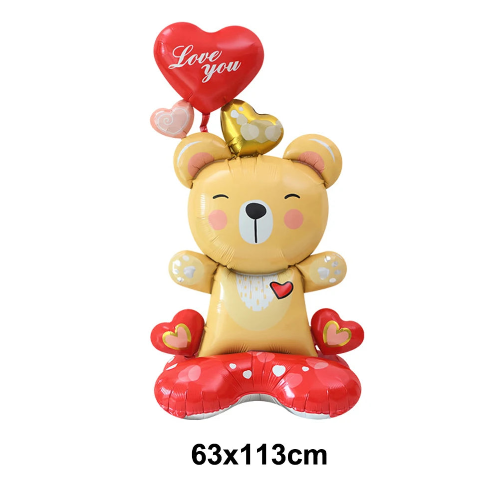 A yellow teddy bear balloon holding a red heart balloon with the words Love you