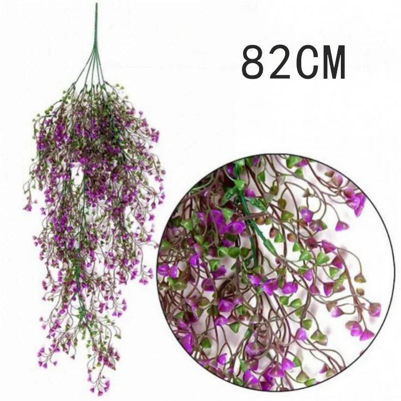 A long, cascading arrangement of purple artificial plant vines used as a wall hanging.