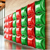A vertical wall display of red and green double-sided square foil balloons for celebrations.