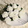 A bouquet of white artificial roses arranged on a white plate, set against a fluffy white background.