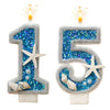 A set of glittery ocean wave number birthday candles shaped like the number 15, featuring blue glitter and starfish decoratio