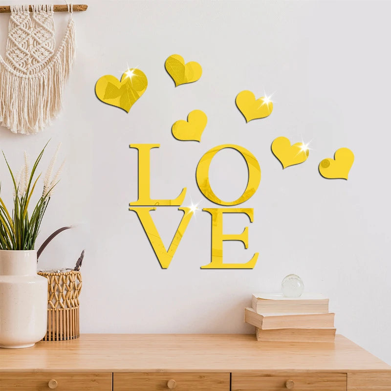 Yellow acrylic heart wall stickers spelling LOVE with a mirror finish on a white wall.