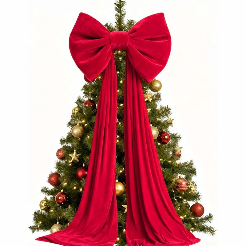A festive Christmas tree decorated with gold ornaments and adorned with a large red velvet bow and long streamers.