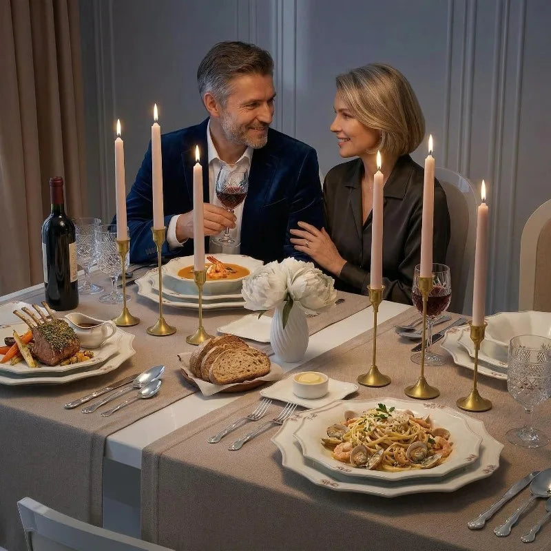 A couple is seated at a table enjoying a meal with vintage metal candle holders and wine glasses.