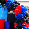 Une arche de ballons noire, rouge et bleue en forme d'araignées et de grappes.