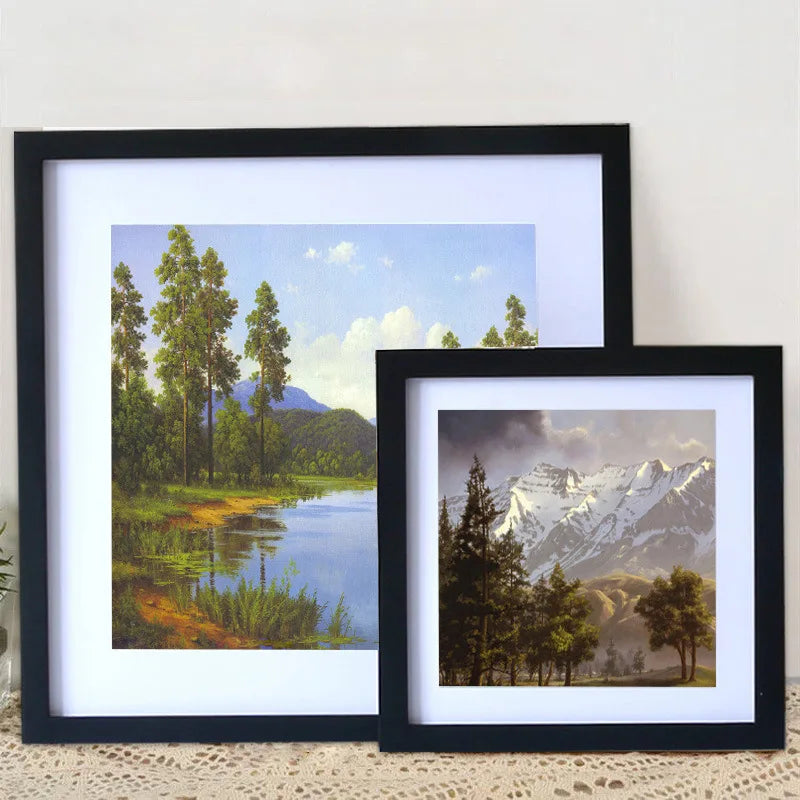 A black framed photo featuring a scenic landscape with trees and mountains.