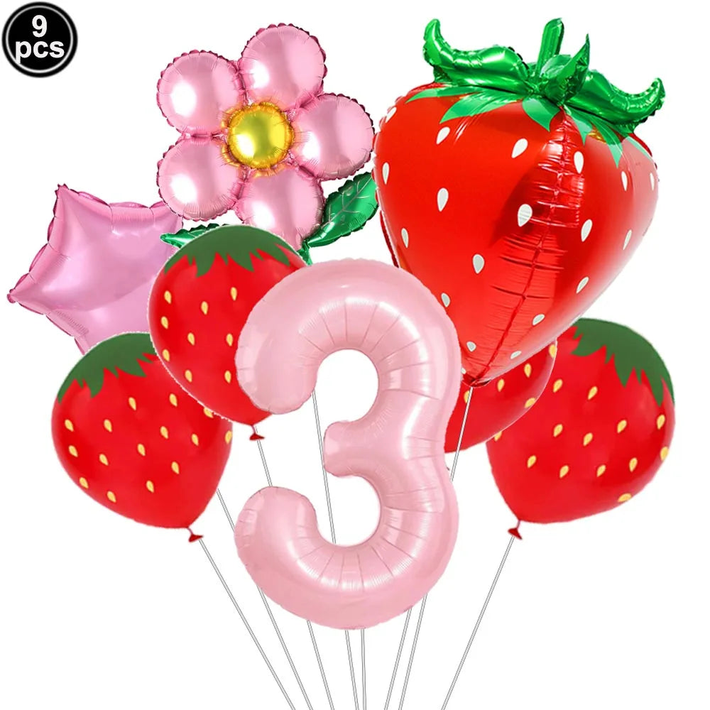 A set of nine pink and red balloon decorations including a strawberry shape and the number three for a party kit