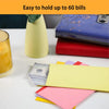 Colorful side-loading cash envelopes stacked on a white surface next to a yellow glass and a blue wallet.