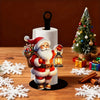 Santa Claus kitchen paper towel holder with festive design standing on a wooden surface surrounded by white snowflakes