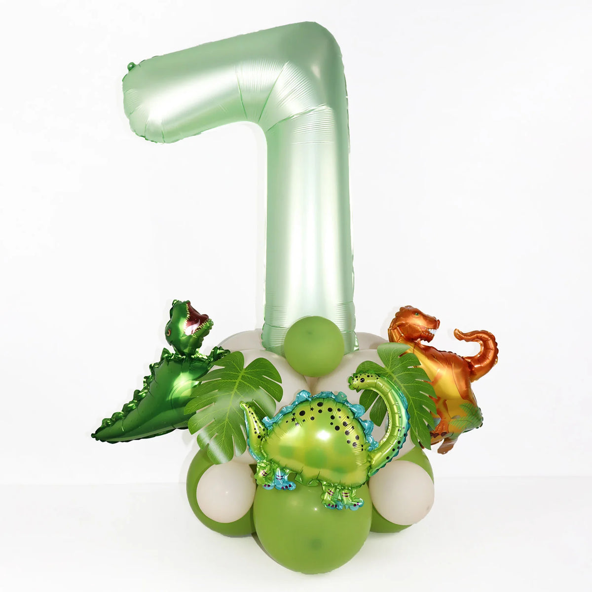 A large, foil number 1 in avocado green is displayed next to a set of dinosaur-themed balloons.