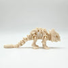 A light beige 3D printed dinosaur skeleton model for desktop display.