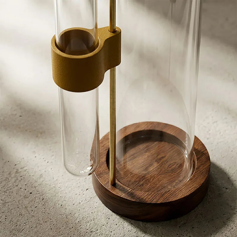 Un brûleur d'encens en verre transparent avec une base en bois et un support couleur laiton pour la méditation ou la décorati