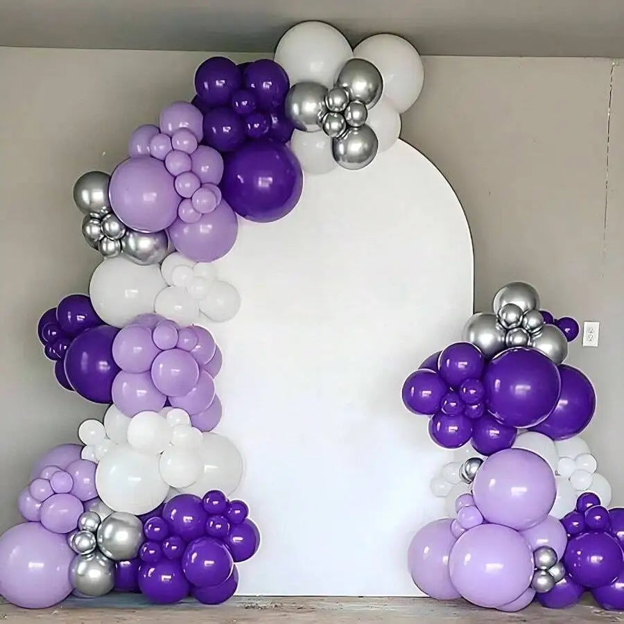 A large balloon arch display featuring dark purple and silver latex balloons against a white background.
