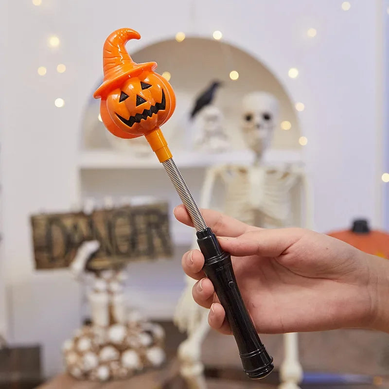 Une main tient une lanterne en bâton orange lumineuse avec un visage de citrouille sculpté contre un arrière-plan flou.