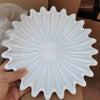 A white lotus leaf resin decorative bowl is held in a hand, showing its radiating petal design.