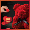 Gros plan d'un ours rose fait de tissu, présenté avec un panneau en forme de cœur indiquant 520 fleurs.
