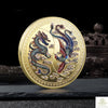 A round gold commemorative coin featuring a Chinese dragon and phoenix design.