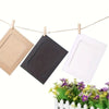 Three vintage kraft paper photo frames are displayed hanging on a line with greenery below.