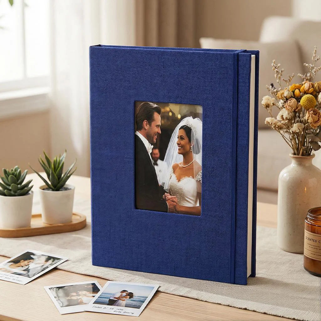 A dark blue linen photo album with a square window displaying a portrait of a bride and groom.