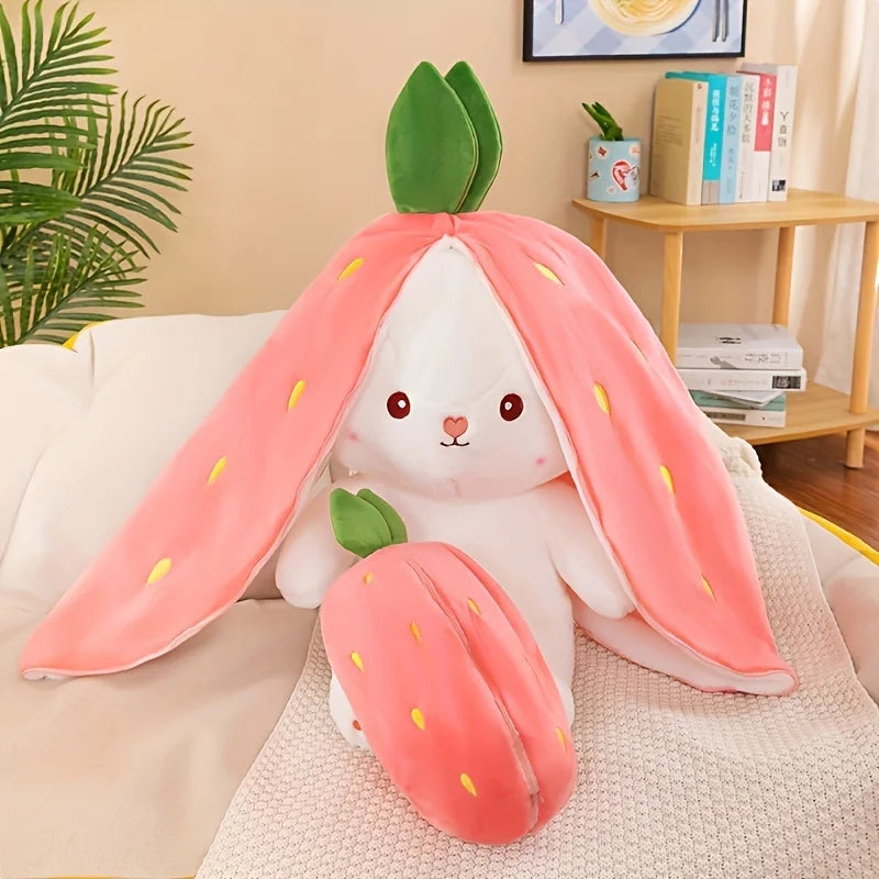 A white bunny plush toy with pink strawberry ears and body, resting on a light-colored fabric.