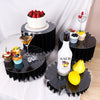 A set of five decorative black acrylic riser stands displaying various desserts and drinks.