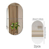 Two oval acrylic mirror wall stickers showing a curtain and a striped pattern.