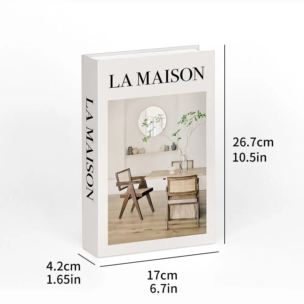 A white book titled LA MAISON with a photograph of a minimalist interior and wooden furniture.