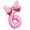 A pink foil balloon shaped like the number six with a large pink bow decoration.