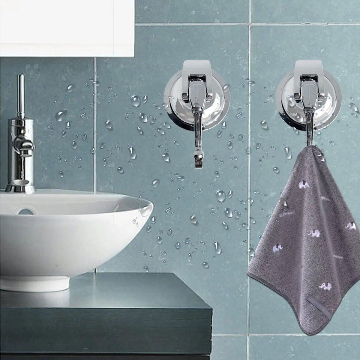 Silver suction cup hooks mounted on a tiled wall above a white vessel sink.