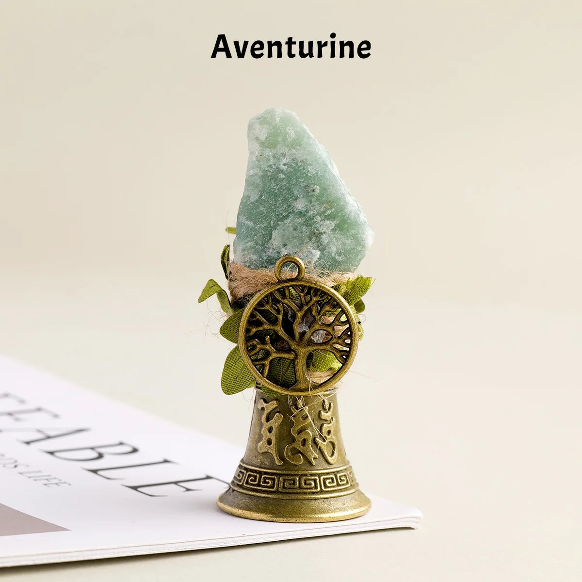 A natural Aventurine crystal mounted in a brass bell with a copper finish.