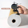 A hand holds a digital thickness gauge measuring 2mm thick metallic gold striped peel-and-stick wallpaper rolled on a spool.