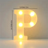 A glowing yellow LED letter P sign illuminates a surface, used for room or party decor.
