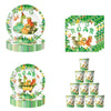A set of dinosaur-themed birthday party supplies including a plate, banner, and cake topper
